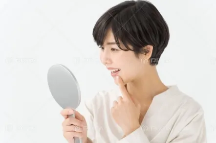 歯を鏡で見る女性